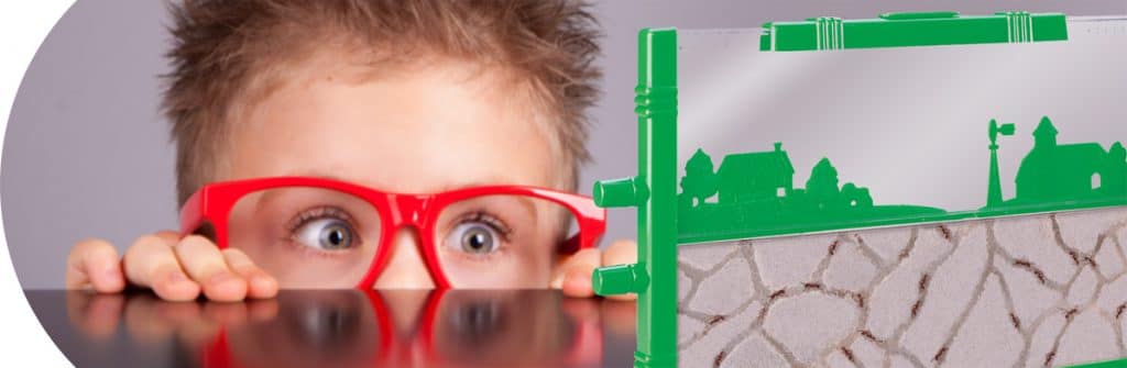 Science and Nature - Boy with red glasses peeking over table at Uncle Milton’s Retro Ant Farm