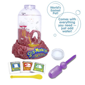 Three packets, numbered 1, 2, and 3 from left to right are vivble in front of the Mars aquarium. There is a small yellow Sea-Monkeys spoon laying in front of the packets, and a purple pipette and clear circle magnifyer next to the spoon. There are two callouts in circles. They read "World's Easiest Pet!", and "Comes with everything you need -- just add water!"